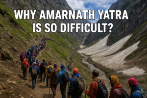 Pilgrims trekking along a steep, snow-covered mountain path during the Amarnath Yatra, surrounded by rugged Himalayan peaks, illustrating the physically demanding and harsh conditions of the journey.